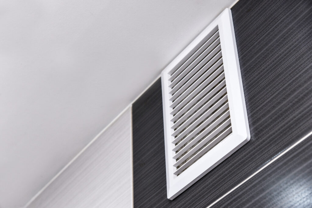 Une grille de ventilation sur un mur noir.