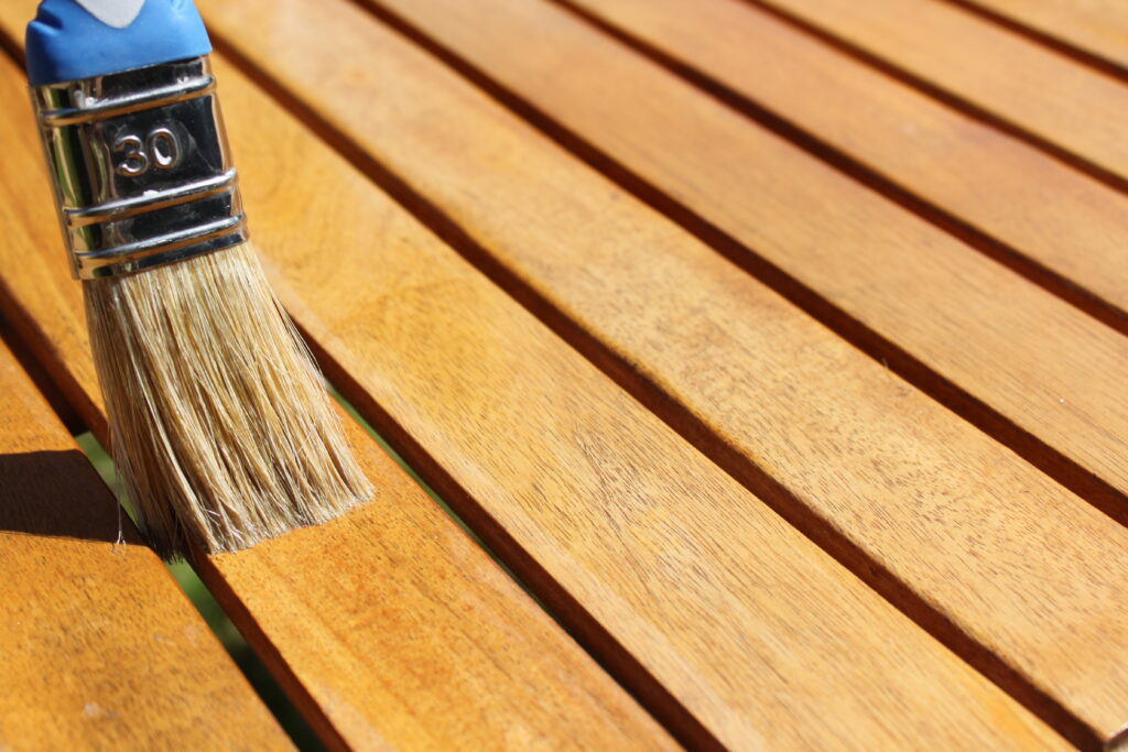 Une personne appliquant du vernis sur du bois.
