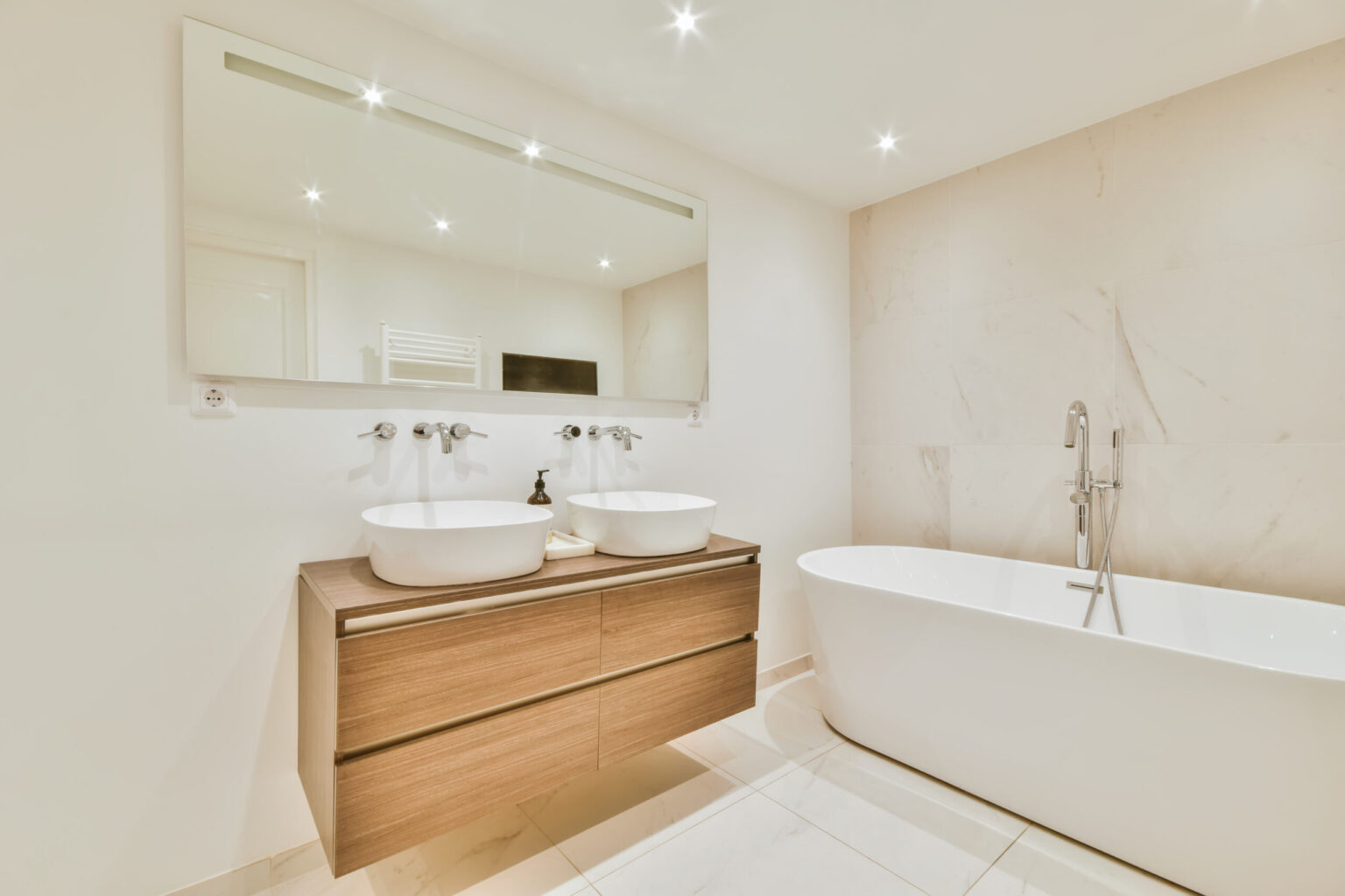 Une salle de bains avec bain et double vasque.