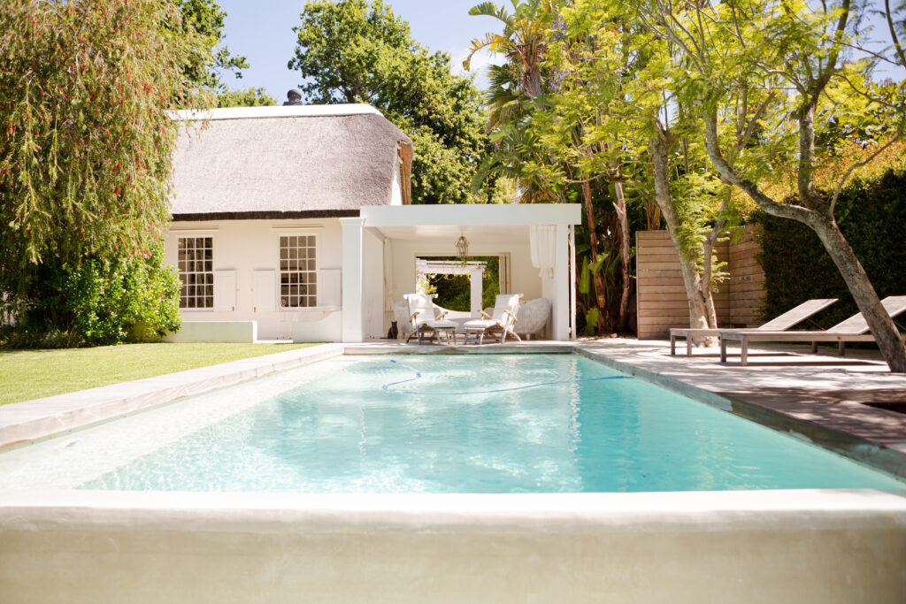 Un pool house, une maison et une piscine.